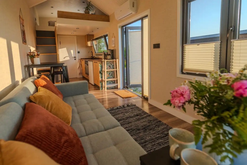 Tiny House Anton helles Wohnzimmer mit Schlafsofa und offener Küche
