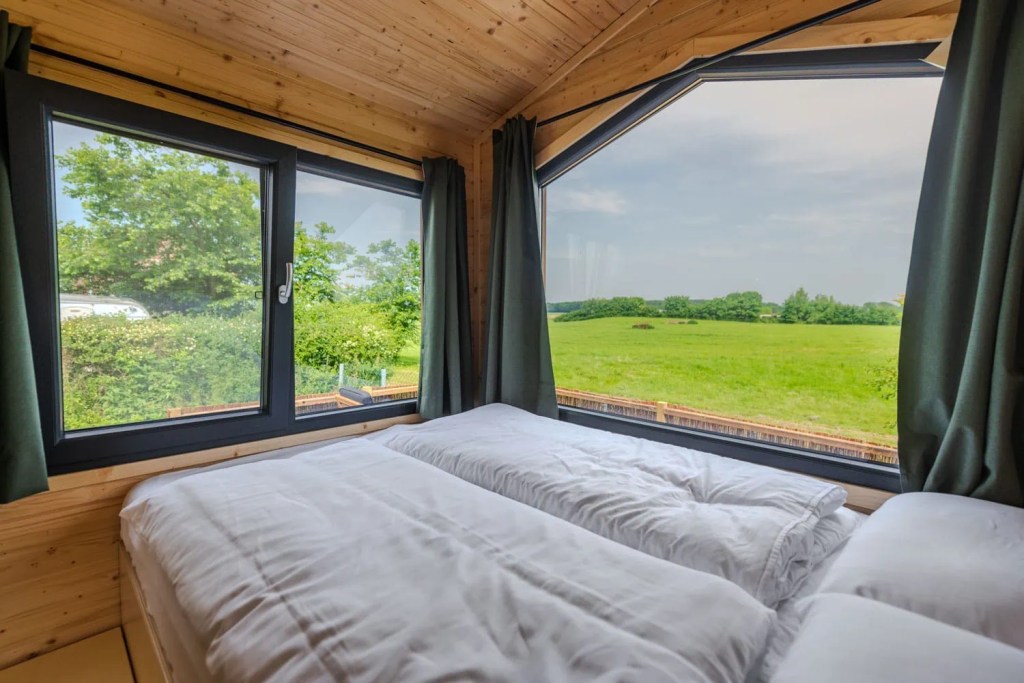Tiny House Mia Panoramafenster mit Blick ins Grüne vom Schlafbereich